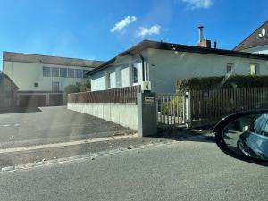 - une vue latérale sur une maison avec une clôture dans l'établissement SUNNYHOME Monteurwohnungen und Apartments in Weiden, à Moosbürg