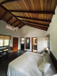 um quarto com uma cama grande e um tecto em madeira em Cottage Garden Bungalows em Mount Lavinia