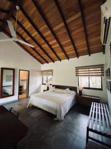 a bedroom with a large bed and a wooden ceiling at Cottage Garden Bungalows in Mount Lavinia