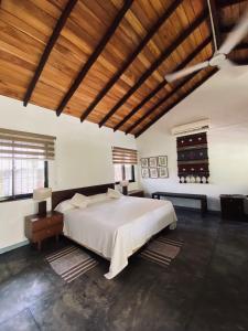 a bedroom with a large bed and a wooden ceiling at Cottage Garden Bungalows in Mount Lavinia +16 photos