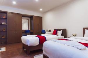 a bedroom with two beds and a closet at Sweet Inn in Bhaktapur
