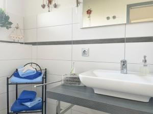 een witte badkamer met een wastafel en een spiegel bij Ferienhaus DolceVita in Walkenried
