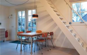 uma sala de jantar com uma mesa de madeira e cadeiras em Lovely Home In Wijdenes With Wifi em Wijdenes