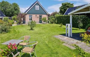 um jardim com mesa e cadeiras e uma casa em Lovely Home In Wijdenes With Wifi em Wijdenes