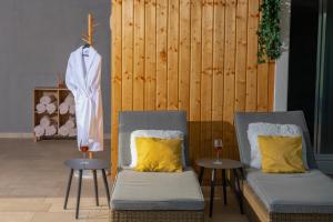 two chairs with yellow pillows next to a wooden wall at Aparthotel Punta Blu in Premantura