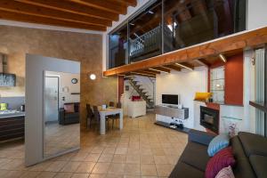 ein Wohnzimmer mit einem Sofa, einer Küche und einer Treppe in der Unterkunft DIAMOND SUITE in Sulzano