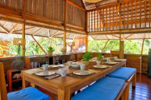 a large wooden table with blue chairs in a room at Loedi Bungalows Rote in Nembrala
