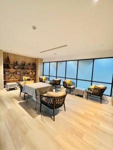 uma sala de jantar com mesas, cadeiras e janelas em The Louts Villa em Chung-lan