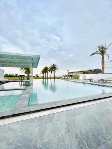 uma piscina com palmeiras e um edifício em The Louts Villa em Chung-lan