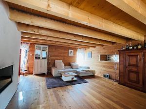 un ampio soggiorno con pareti in legno e divano di Chalet Biene - Swiss Alp Chalet with Sauna and Jacuzzi a Ulrichen