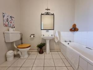 a bathroom with a toilet and a sink and a tub at Mansfield Private Reserve in Port Alfred +83 photos