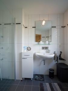 a white bathroom with a sink and a shower at Ferienwohnung Grete in Merzig