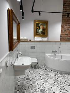 a bathroom with a tub and a toilet and a sink at Apartamenty Żeglarska 25 in Toruń