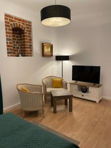 a living room with two chairs and a flat screen tv at Apartamenty Żeglarska 25 in Toruń