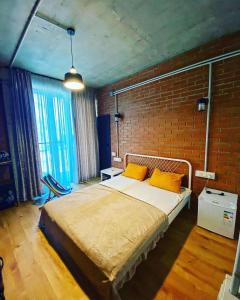 ein Schlafzimmer mit einem Bett und einer Ziegelwand in der Unterkunft shekvetili in Shekhvetili