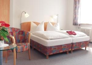 Hotel Bären في فيلينغن شفيننغن: غرفة نوم بسرير واريكة وطاولة
