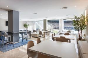 eine Cafeteria mit Tischen und Stühlen in einem Stadion in der Unterkunft B&B HOTEL Jerez in Jerez de la Frontera