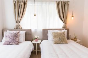 2 łóżka w sypialni z oknem w obiekcie Bijou Suites Sorriso - Vacation STAY 82795 w Osace