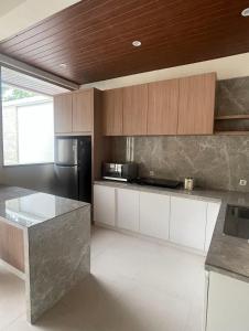 een keuken met een zwarte koelkast en witte kasten bij Blue Breeze Villa in Lajor