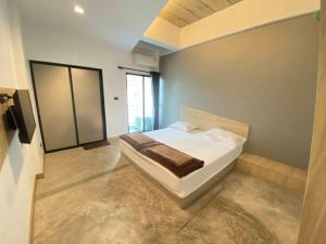 a bedroom with a white bed in a room at Newman hotel in Ban Khlong Ha