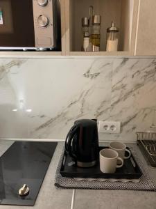 a coffee maker and two cups on a tray in a kitchen at DM apartman Beograd in Vračar (historical)