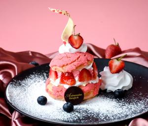 un dessert rose avec des fraises et de la crème fouettée et des baies dans l'établissement Ambassador Hotel Bangkok - SHA Extra Plus, à Bangkok