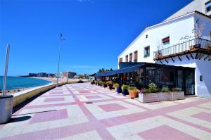a sidewalk next to a building next to the beach at LUXURY HOUSE 8 PERSONS FRONT THE BEACH BLANES COSTA BRAVA in Blanes