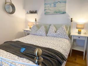 a bedroom with a bed with two night stands at Laughing Seagull Cottage - unspoilt sea views in Castletownbere