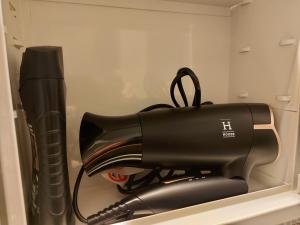 a black hair dryer sitting on a shelf at Yksiö keskustan lähettyviltä in Oulu