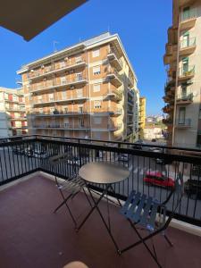 een tafel en stoelen op een balkon met een gebouw bij Morelli B&B in Rossano Stazione