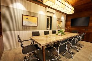 a conference room with a large table and chairs at Visthara Hotel in Bengaluru