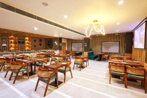 a dining room with wooden tables and chairs at Visthara Hotel in Bangalore