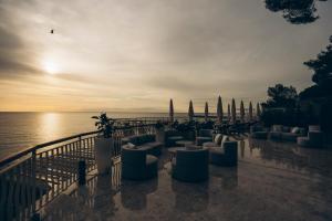 eine Gruppe von Sofas und Stühlen auf einer Terrasse in der Nähe des Wassers in der Unterkunft Hotel Arc En Ciel in Diano Marina