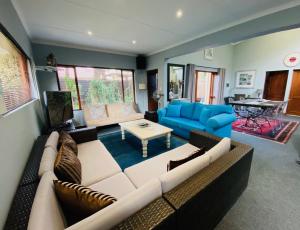 a living room with a couch and a table at Serendipity Cottage in Johannesburg