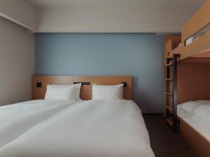 1 dormitorio con 1 cama grande y 2 almohadas en MIMARU Tokyo IKEBUKURO, en Tokio