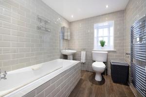 a bathroom with a tub and a toilet and a sink at JOIVY Stylish flat near Perth Museum in Perth