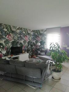 sala de estar con sofá y algunas plantas en La conviviale, en Saintes