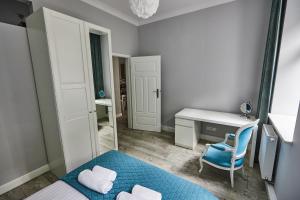 Kleines Zimmer mit einem Schreibtisch und einem blauen Stuhl. in der Unterkunft Niebieski Apartament DE LUX dla 4 osób Chorzów Katowice in Chorzów