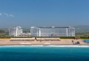 ein großes Gebäude mit Strand davor in der Unterkunft Calido Maris Hotel Ultra All Inclusive in Kızılot
