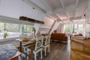 ein Esszimmer und ein Wohnzimmer mit Tisch und Stühlen in der Unterkunft La Petite Ourse Durbuy - natuur chalet in het bos in Durbuy