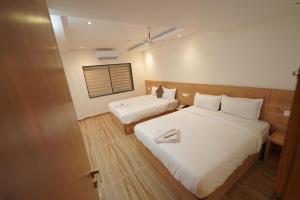 a hotel room with two beds and a window at Southern Residency in Cochin