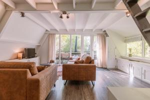ein Wohnzimmer mit zwei Sofas und einem großen Fenster in der Unterkunft La Petite Ourse Durbuy - natuur chalet in het bos in Durbuy