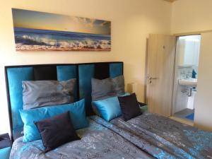 1 dormitorio con 1 cama con sábanas y almohadas azules en Tante Emma Sydney, en Paderborn