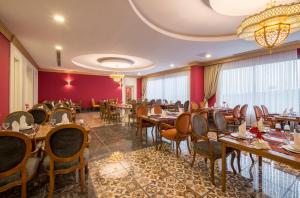 ein Restaurant mit Holztischen und -stühlen und roten Wänden in der Unterkunft Calido Maris Hotel Ultra All Inclusive in Kızılot
