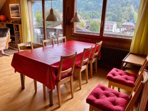 a dining room with a table and chairs and a large window at Gemütliche Dachwohnung im Chalet mit Bergblick in Engelberg