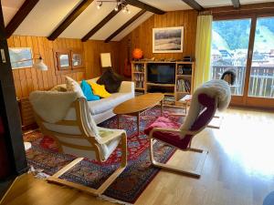 a living room with two chairs and a couch at Gemütliche Dachwohnung im Chalet mit Bergblick in Engelberg