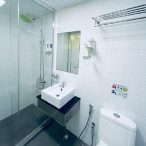 a white bathroom with a sink and a toilet at Green Apple Boutique Hotel in Kota Kinabalu