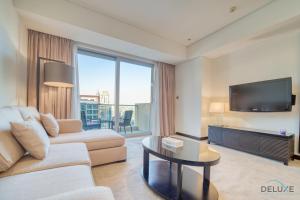 sala de estar con sofá y TV en Pristine 1BR in The Address Residences Dubai Marina by Deluxe Holiday Homes en Dubái