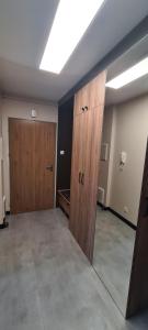 pusty pokój z dwoma drewnianymi drzwiami i ścianą w obiekcie Apartamenty Homely - Nowowarszawska 130 w mieście Białystok