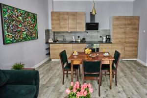 eine Küche und ein Esszimmer mit einem Tisch und Stühlen in der Unterkunft Zielony Apartament DE LUX dla 4 osób Chorzów Katowice in Chorzów